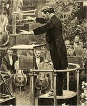 drawing of a middle-aged man in evening dress, seen from his left, conducting an orchestra