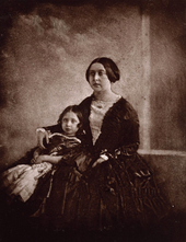 Victoria cuddling a child next to her