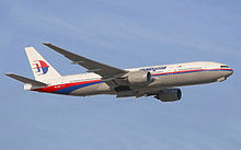 Airliner takeoff. Side view of jet ascending in the sky, with landing gear in partially retracted position.