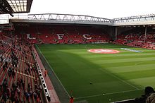 The interior of a stadium which has red seats.