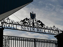 Design of the top of a set of gates, with the sky visible. The inscription on the gates reads 