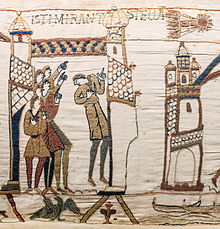 White embroidery showing several people on the left pointing to Halley, top right, over a tower